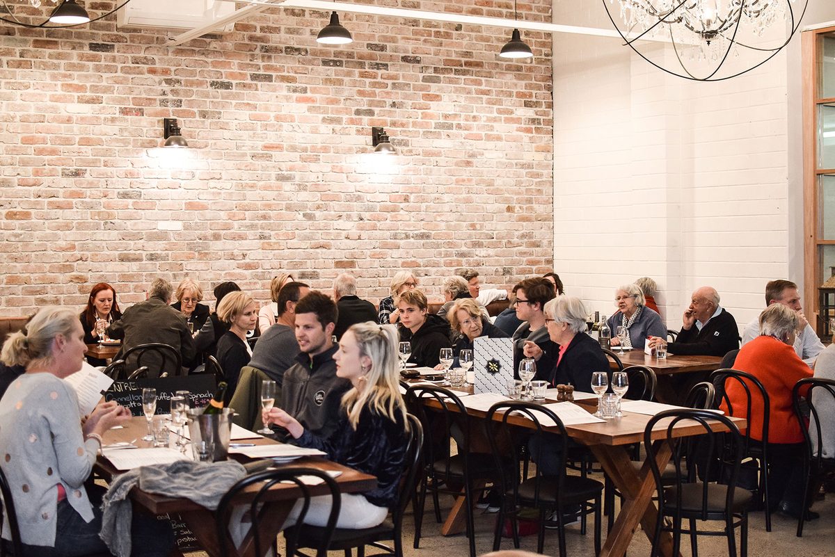 A long table of guests dining together at Lucky and Pep's